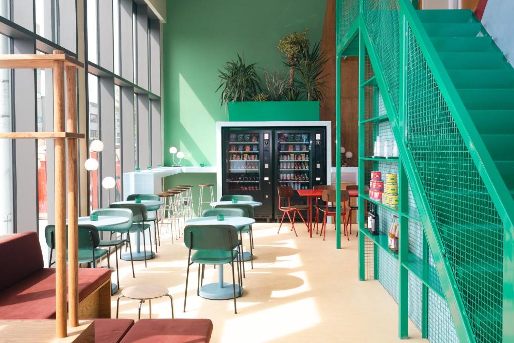 een restaurant met groene muren en tafels en stoelen bij Poppies in Amsterdam
