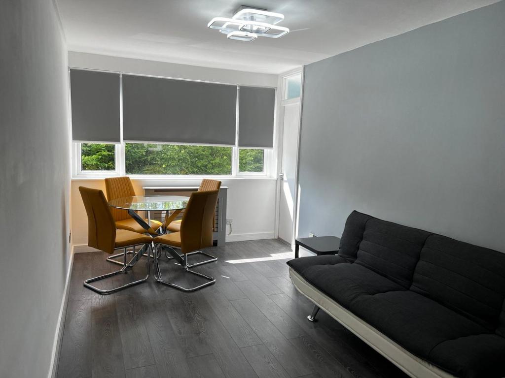 a living room with a couch and a glass table at Stylish Stays - Luxury Apartment for 3 in Manchester