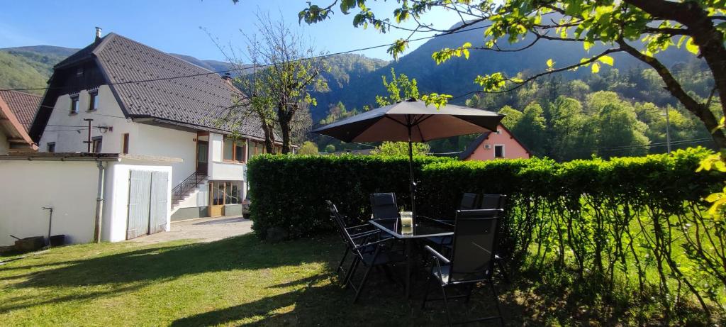 a table and chairs with an umbrella in a yard at Apartma Soča Oasis in Srpenica