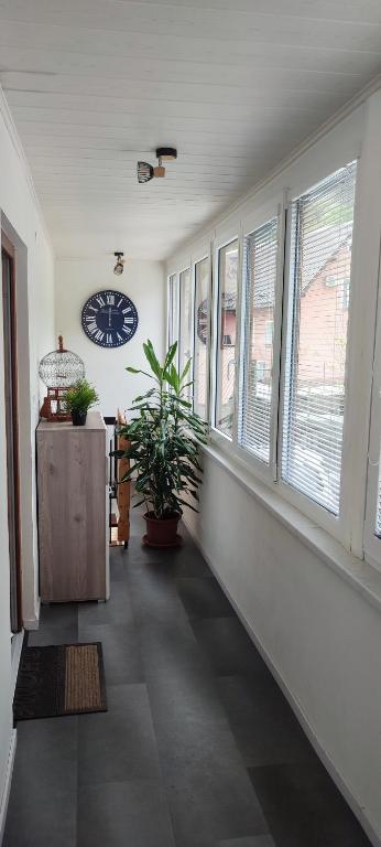 a hallway with windows and a clock on the wall at Apartma Soča Oasis in Srpenica