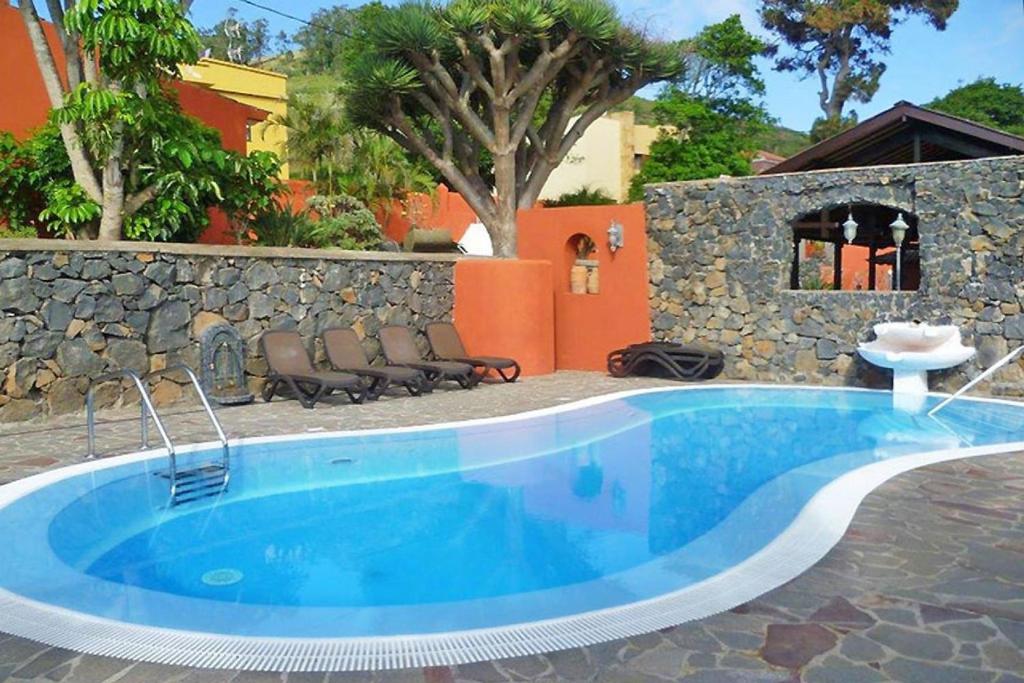 ein großer blauer Pool neben einer Steinmauer in der Unterkunft Ferienhaus für 10 Personen in La Caridad, Teneriffa Nordküste von Teneriffa in Tacoronte