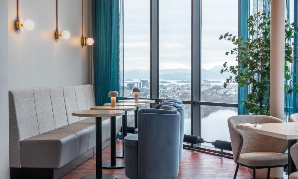 スタヴァンゲルにあるThon Partner Stavanger Forum Hotelのテーブルと椅子、大きな窓のあるレストラン