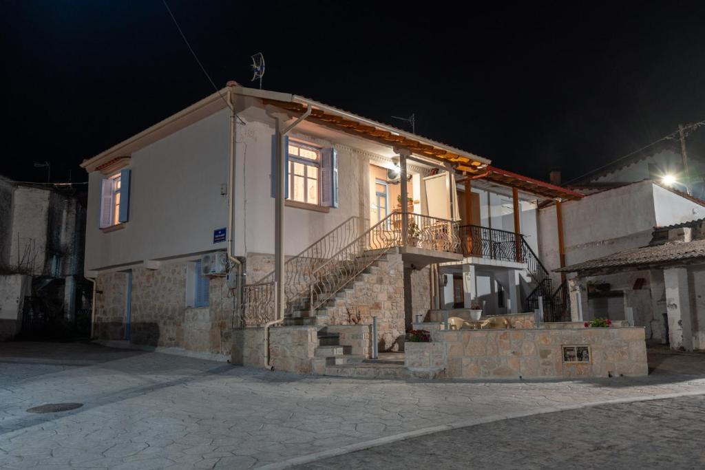 una casa con escaleras y una ventana por la noche en Patriko Retro House en Fourka