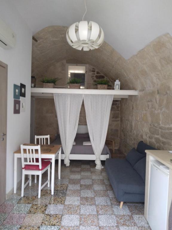 a living room with a table and a couch at Piazzetta Scolanova in Trani