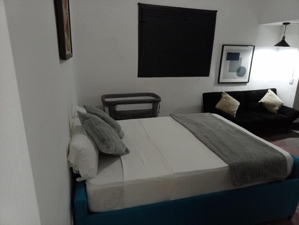 1 dormitorio con 1 cama grande y 1 silla en Confortable Loft MN 960 F Centro, en Monterrey