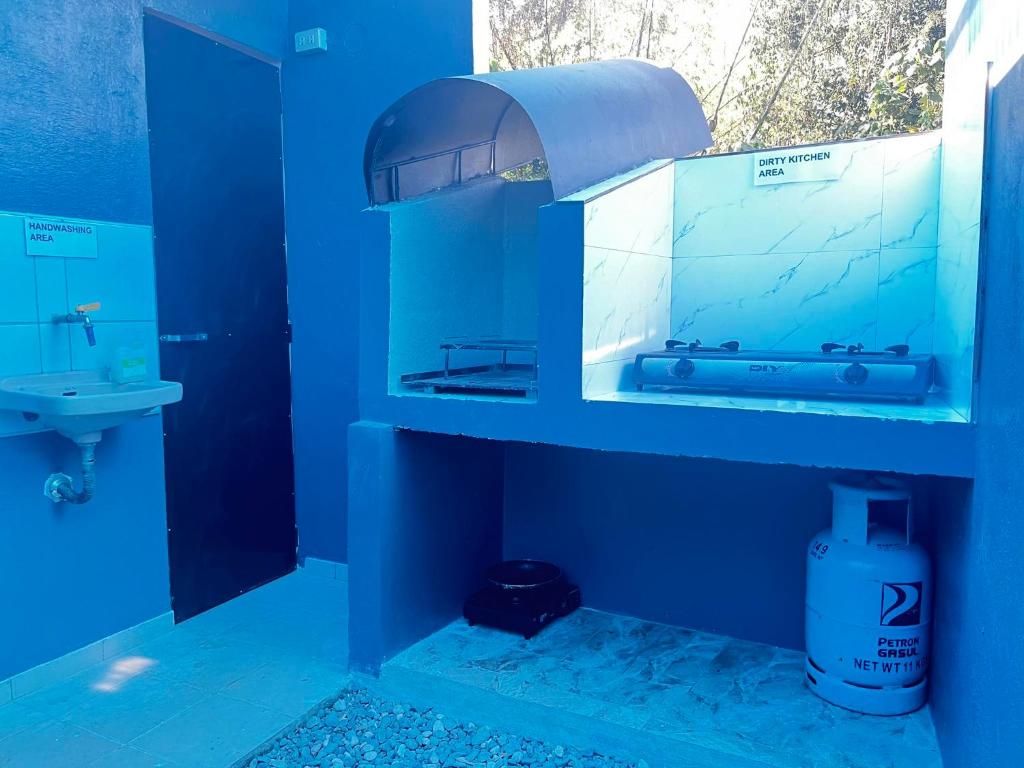 Baño azul con lavabo y espejo en Shawe pension house, en San Remigio