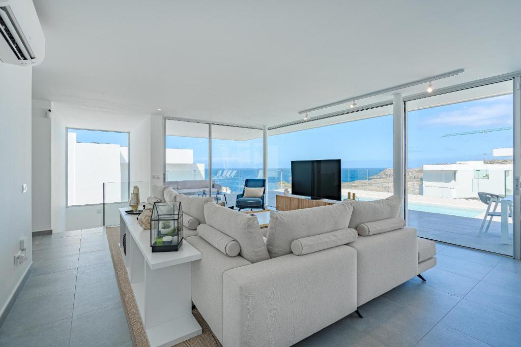 Una sala de estar con un sofá blanco y un televisor. en Villa Estándar 1 - Casangular by Upper, en Adeje