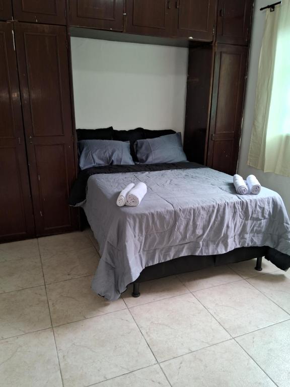 Una cama con dos zapatillas en un dormitorio en Casa espaçosa em Belo Horizonte, en Belo Horizonte