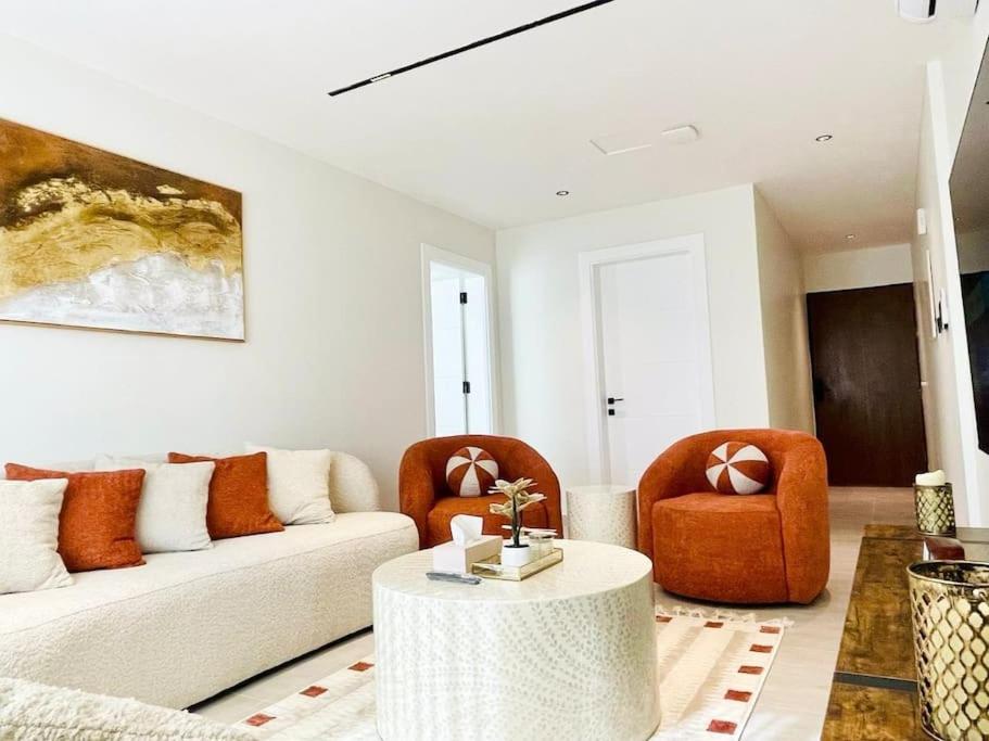 ein Wohnzimmer mit einem Sofa und 2 Stühlen in der Unterkunft Spacious new 2 bedroom Apt-in amazing location B33 in Riad