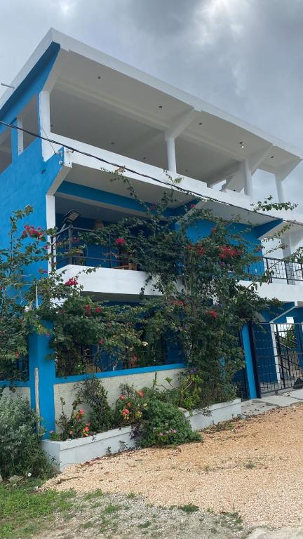 a blue building with flowers on the side of it at Posada - Casa Recreacional Guasimal in Bávaro