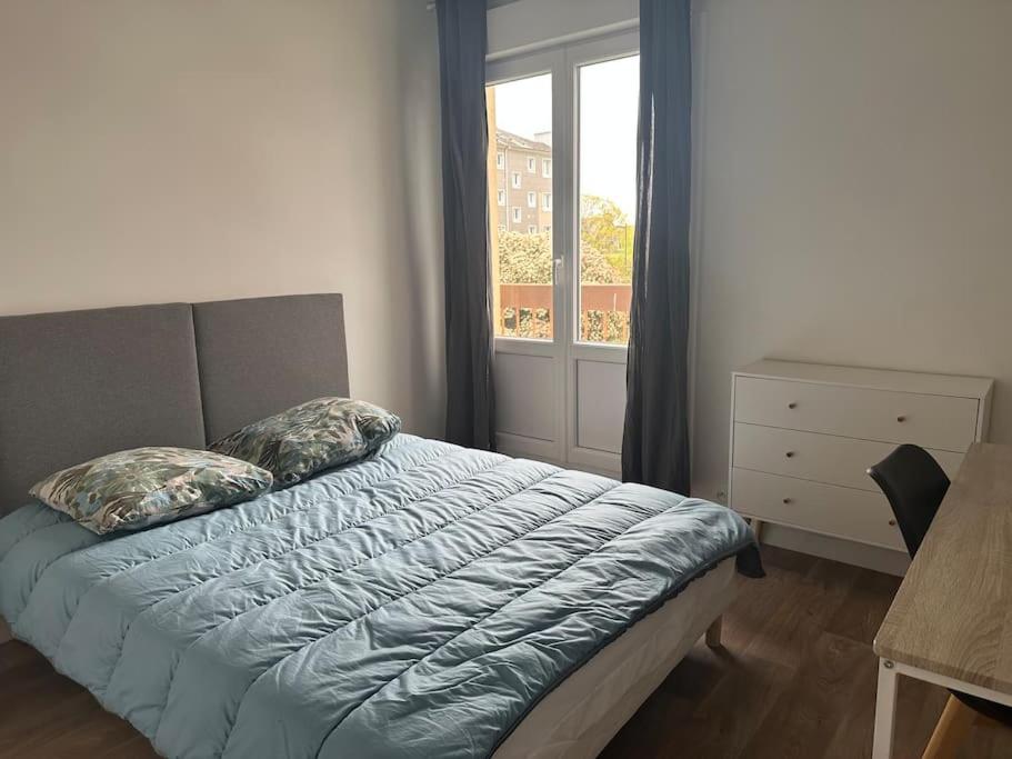 um quarto com uma cama, uma janela e uma secretária em L'escapade Familial seh'loué em Saint-Brieuc