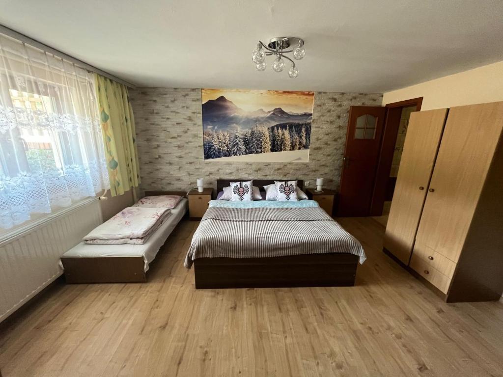 什切爾克的住宿－POKOJE GOŚCINNE U ANIELI，一间卧室设有两张床,墙上挂着一幅画
