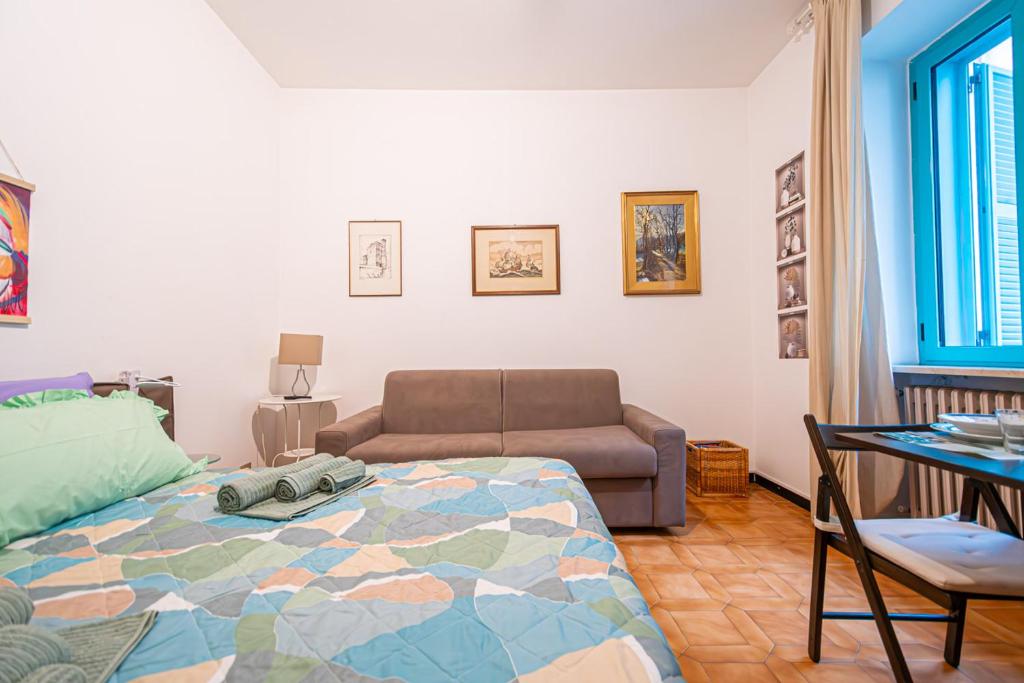 een slaapkamer met een bed, een bank en een tafel bij VALENTINO in Turijn