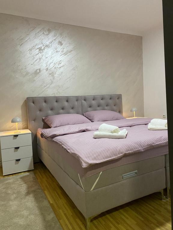 a bedroom with a bed with pink sheets and pink pillows at Apartman Nađa in Bileća