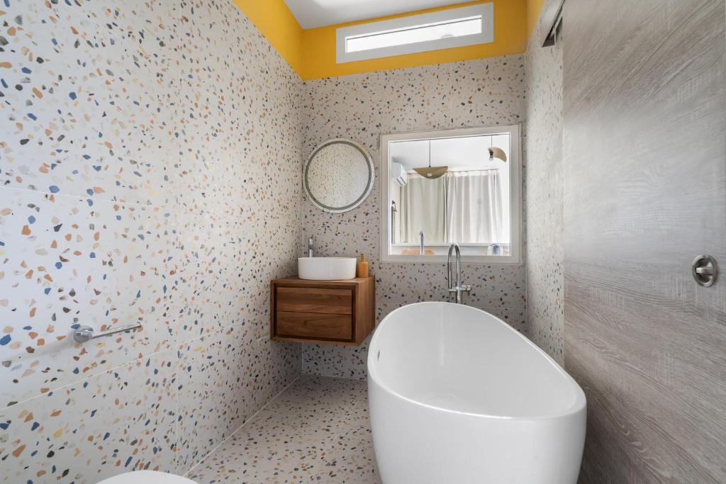 La salle de bains est pourvue de toilettes blanches et d&#39;un miroir. dans l&#39;établissement Jardin Chic, à Fort-de-France