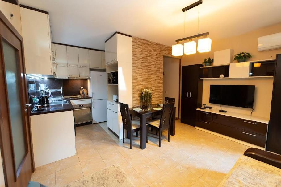 uma cozinha e sala de jantar com mesa e cadeiras em Апартамент за гости Уют em Burgas