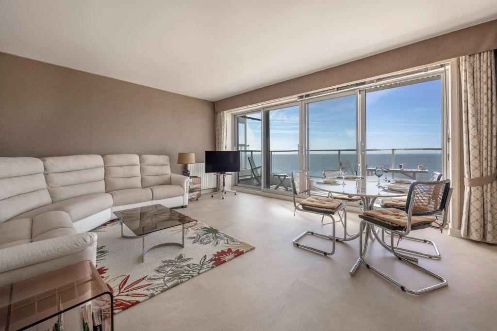 un salon avec un canapé et une table dans l'établissement Splendide vue mer et en front de plage!, à La Baule