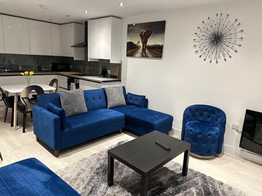 a living room with a blue couch and a kitchen at Kyoto House Central I Brand New Built House I 6 Guest I Contractors and Family Friendly in Derby