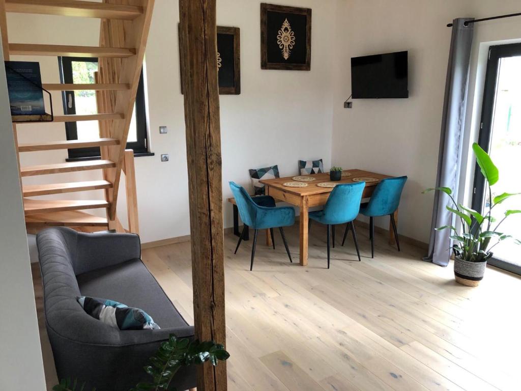 a living room with a dining room table and blue chairs at Domek Zgredek in Żywiec