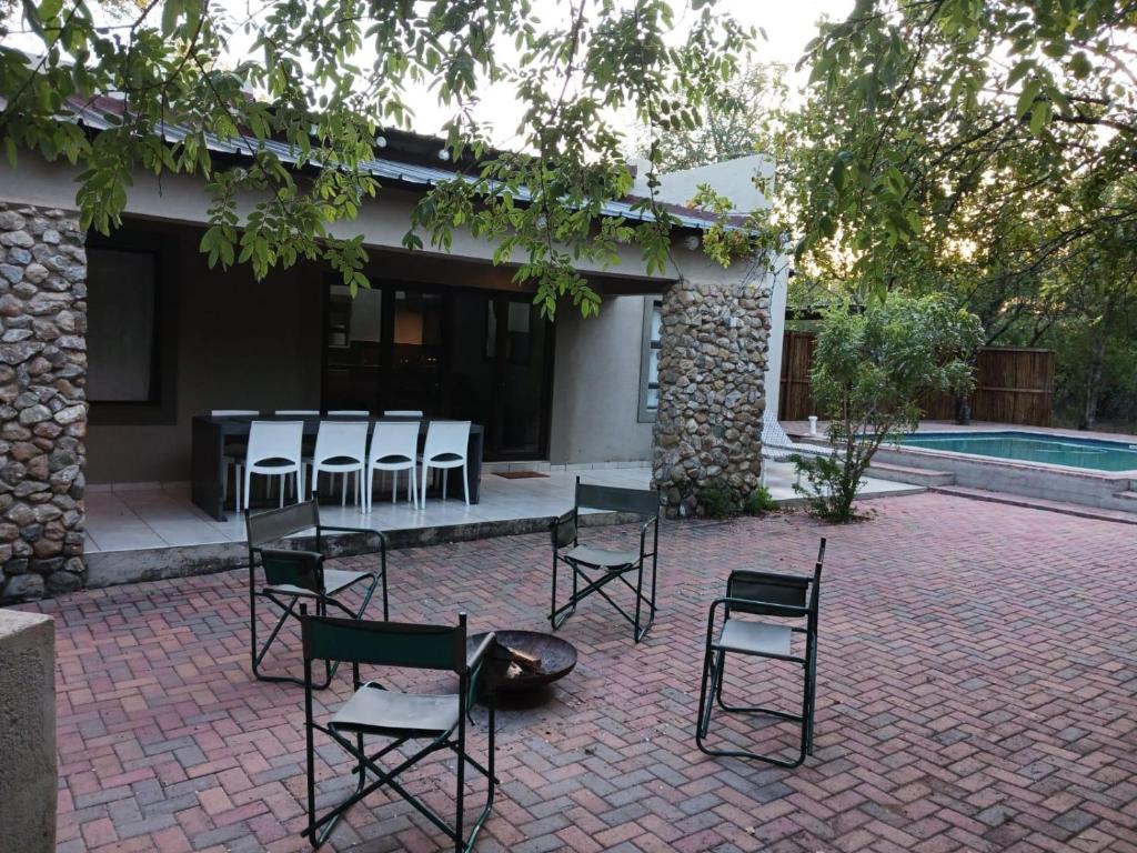 a group of chairs and a table in front of a house at Marloth Cottage in Marloth Park