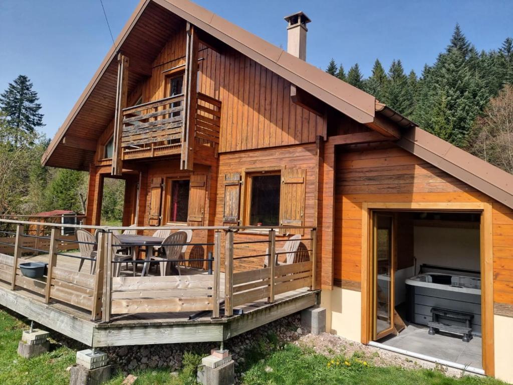 a log house with a deck and a grill at Le chalet des Broches - jacuzzi in Xonrupt-Longemer