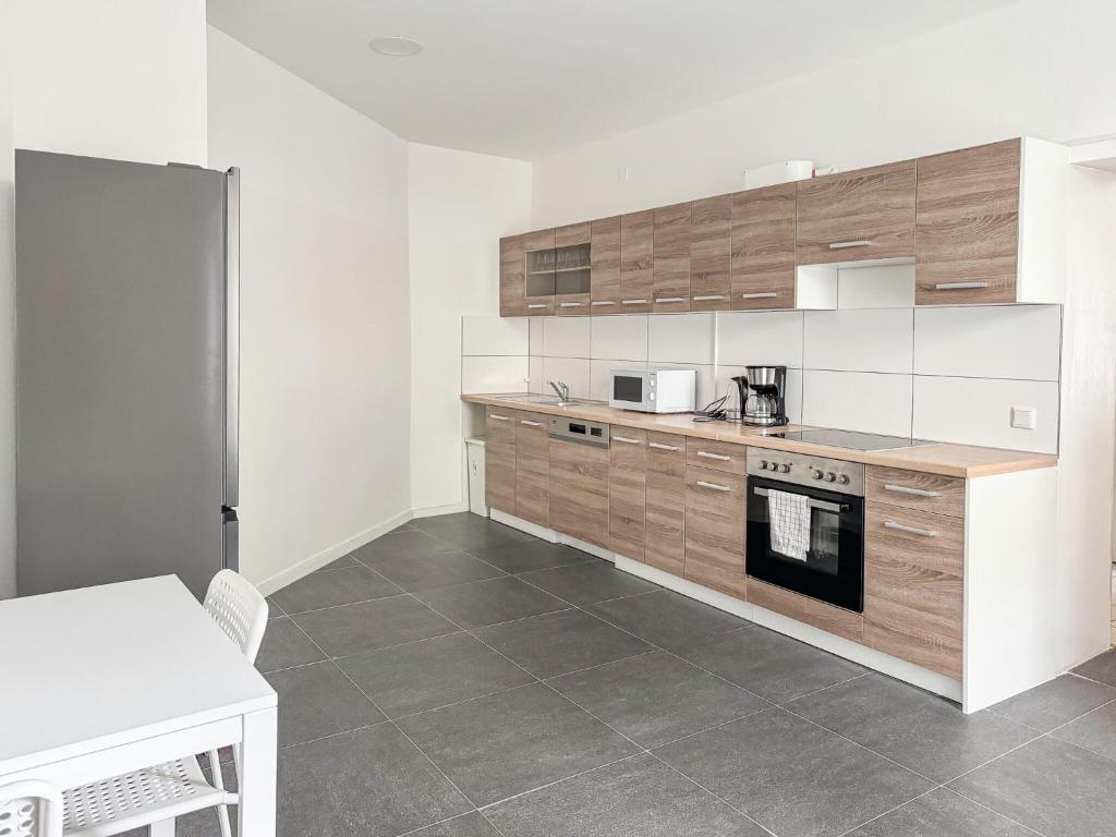 uma cozinha com armários de madeira e um forno com placa de fogão em 6 room detached house - Köln Messe Fair 10min em Colônia