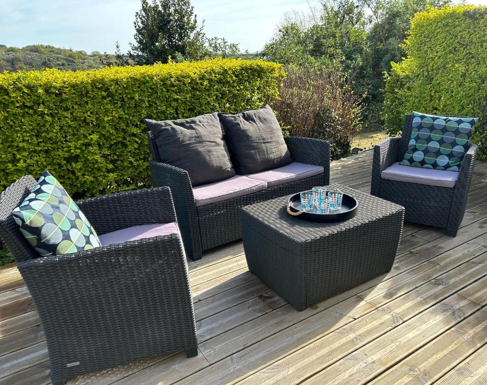 three wicker chairs and a table on a deck at Jean Bart - proximité centre - 2 chambres 90 m2 avec jardin in Saint-Brieuc