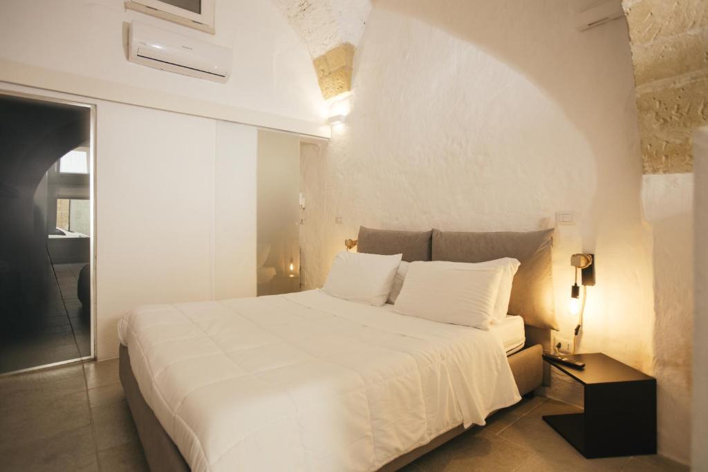 a bedroom with a large white bed with white sheets and pillows at Mediterranee Suite in Lecce