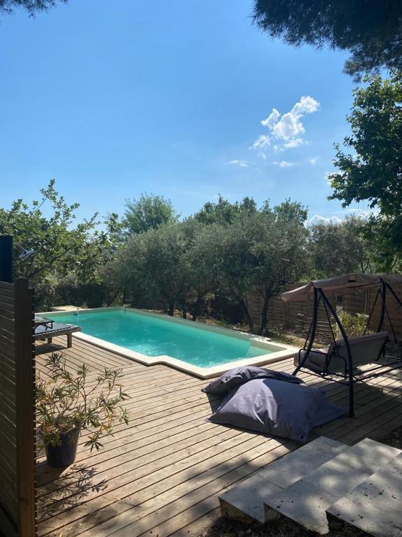 - une piscine sur une terrasse en bois avec un lit à côté dans l'établissement Magnifique villa toute climatisée, à Éguilles