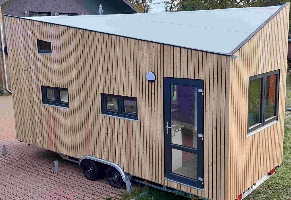 a tiny house sitting on top of a brick yard at Tiny Haus Blanker Hans auf dem Campingplatz Strandgut in Cuxhaven