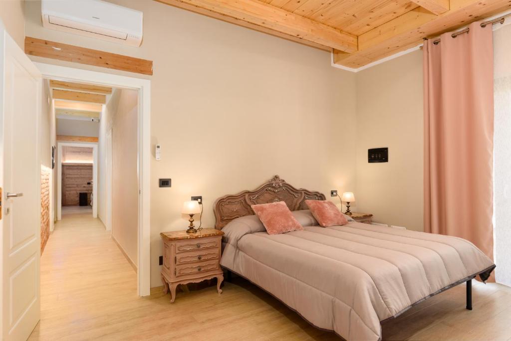 - une chambre avec un grand lit et un plafond en bois dans l'établissement Cascina Cavallo, à Canale