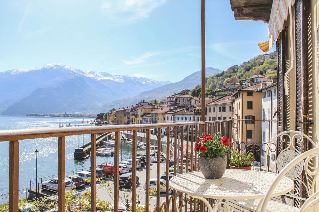 a balcony with a table and chairs and a view of the water at Appartamento Francisca, Domaso, Como Lake in Domaso