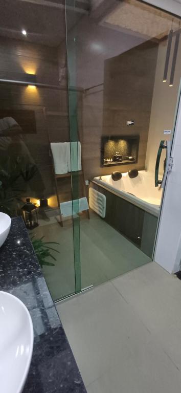 a bathroom with a glass shower and a sink at Pepalantus Flats in Santana do Riacho