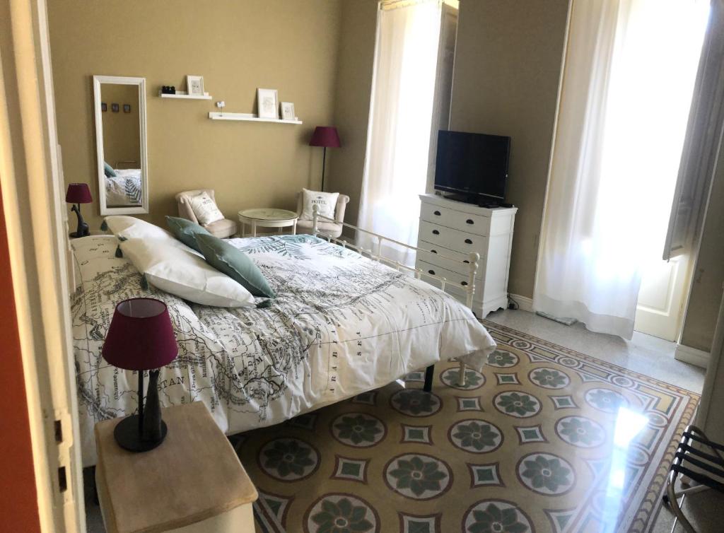 - une chambre avec un lit, une commode et une télévision dans l'établissement Appartamento Vento D'Estate, à Bagheria