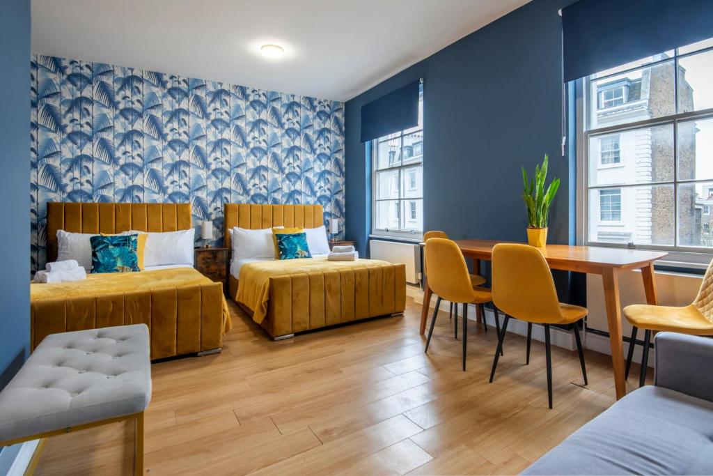Habitación con 2 camas, mesa y sillas en BRAND NEW The Palms: Luxury Family Residence, en Londres