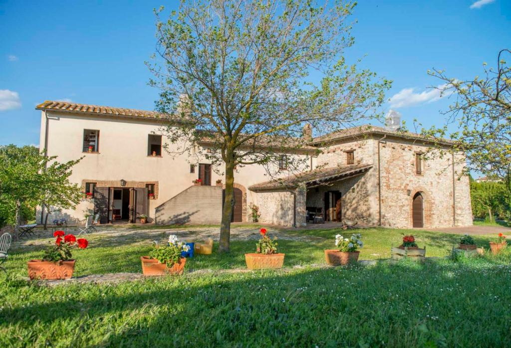 una vieja casa de piedra con macetas en el patio en Agriturismo Piano Grande en Avigliano