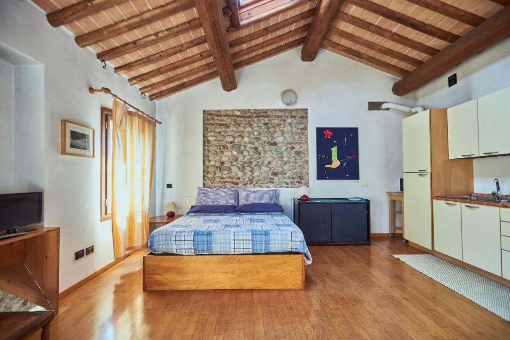 a bedroom with a bed and a stone wall at Mansarda - Bassano Dieda in Bassano del Grappa