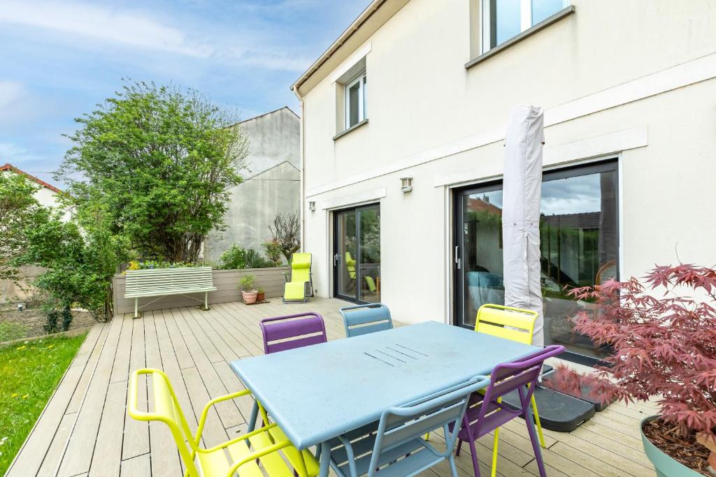 un patio avec une table bleue et des chaises sur une terrasse dans l'établissement Magnifique maison avec jardin et salle de jeux proche Paris, à Villejuif