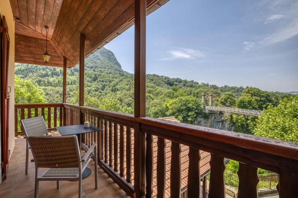 a porch with chairs and a table and a view of a mountain at Auberge du pont de l'Abîme in Gruffy