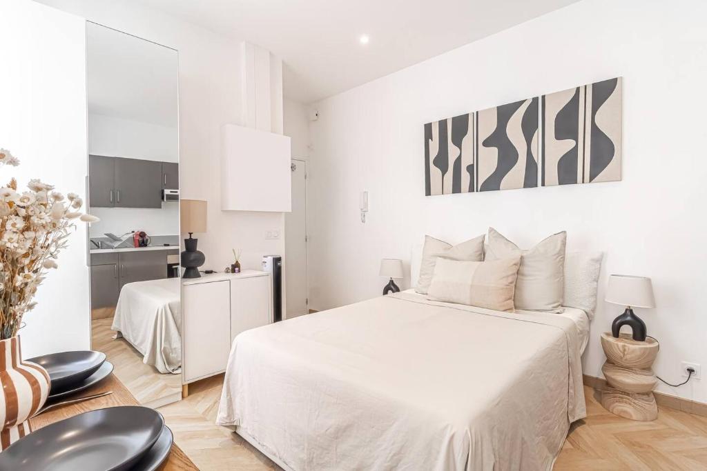 um quarto branco com uma cama branca e uma cozinha em Nice Studio Close To Monaco em Beausoleil