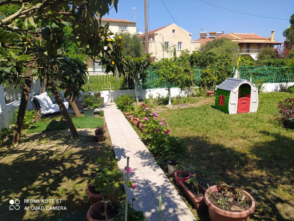 un jardín con una casa de perros y algunas plantas en Elenas Garden, en Kavos