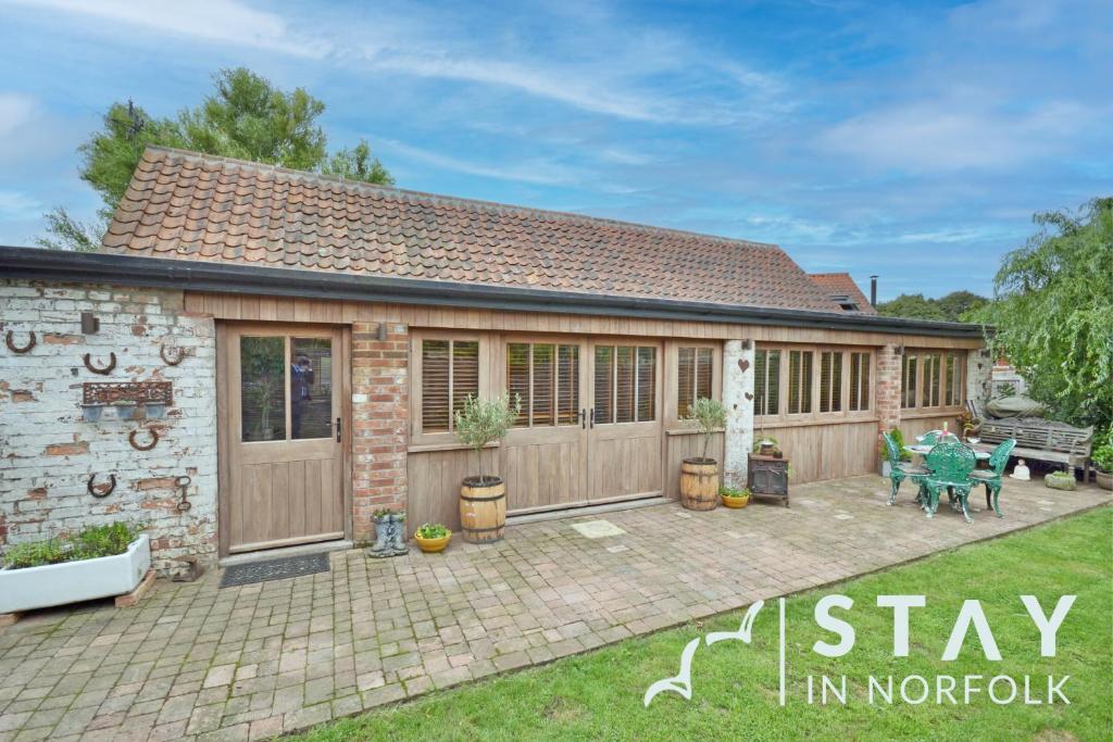 a detached house with a garden and patio at The Old Forge in Dersingham
