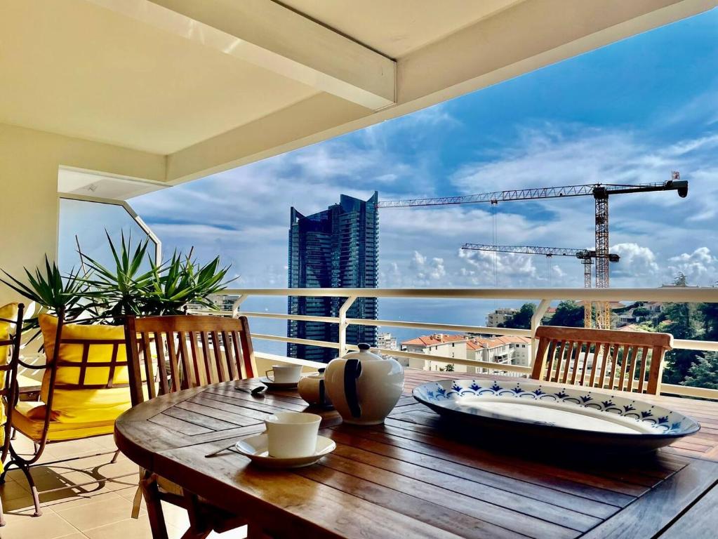 2 Rooms In Luxury Residence Bordering Monaco في بوسولاي: طاولة على شرفة مطلة على مبنى