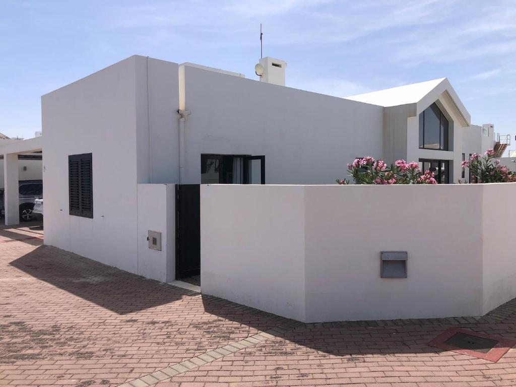 a white building with flowers on top of it at Las Buganvillas 77 in Playa Blanca