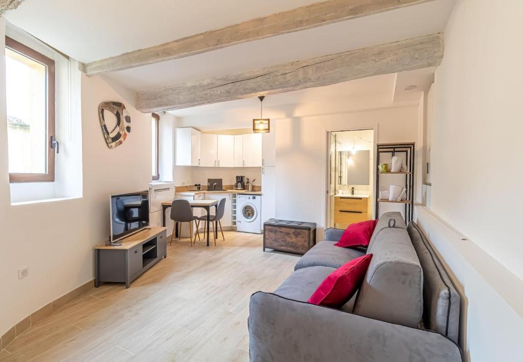 a living room with a couch and a kitchen at Modern Studio In The Heart Of Old Menton in Menton