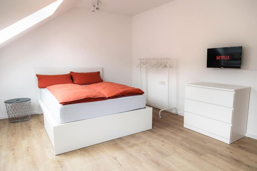 カッセルにあるKassel Rooms Iの白いベッド(オレンジ色の枕付)
