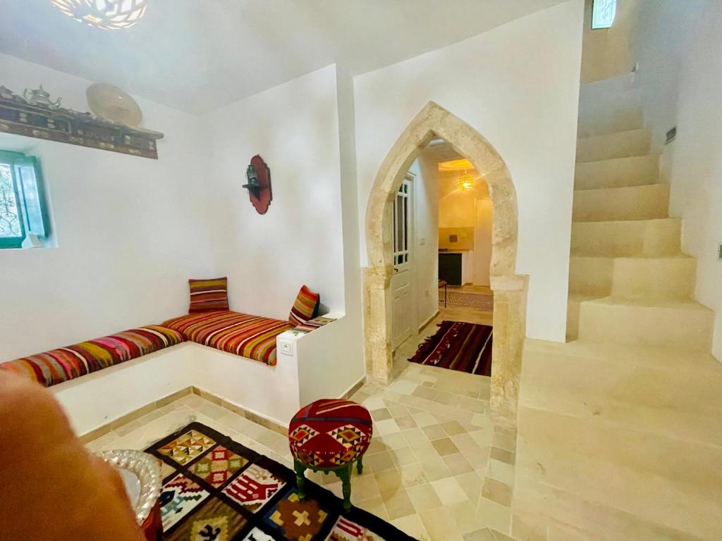 a living room with a couch and a staircase at DIAR HAROUN in Djerba