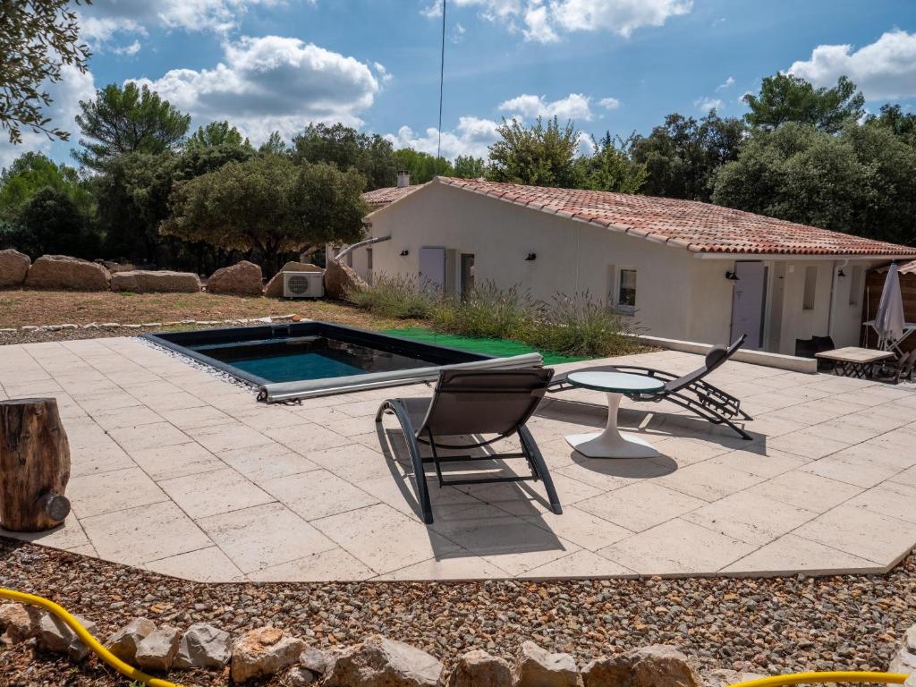 una casa y un patio con piscina y 2 sillas en Douceur d'Olive - Maison avec piscine privée, en Fox-Amphoux
