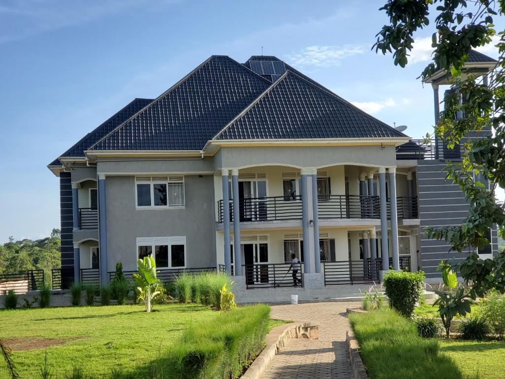 a large house with a black roof at Bigodi Community Homestay in Kamwenge