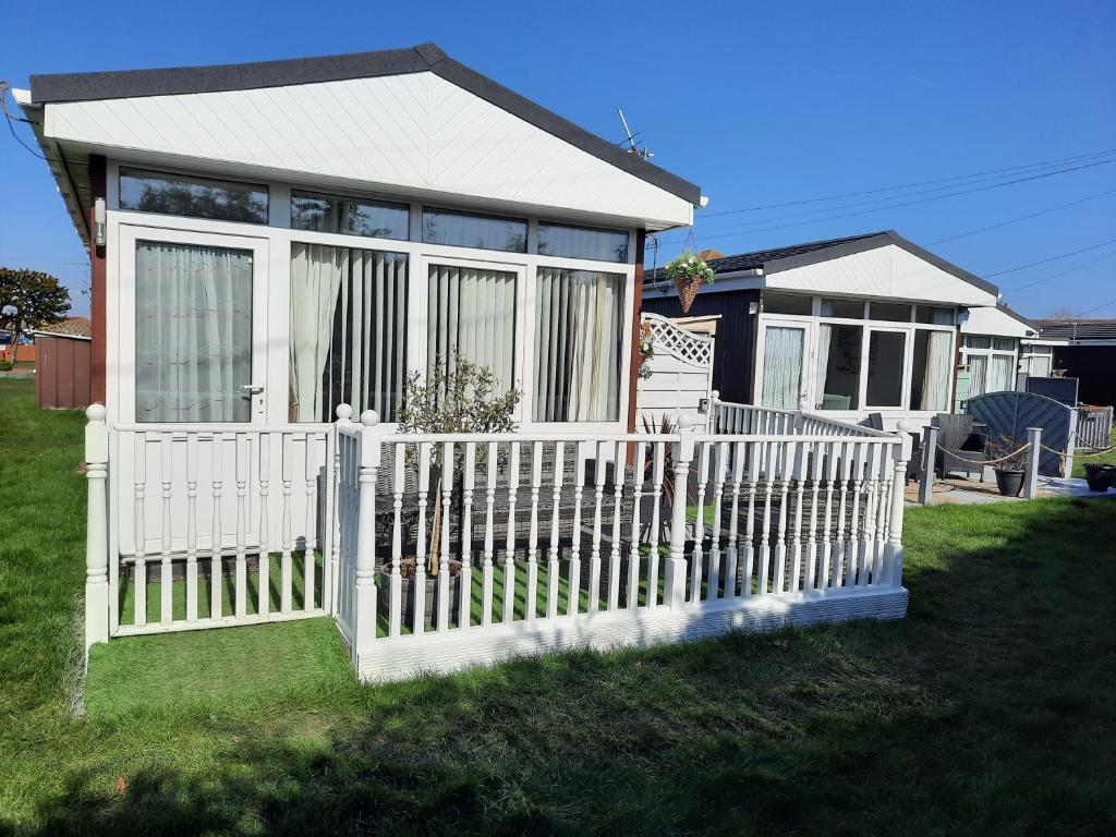 a white picket fence in front of a house at Family Tides-Chapel Saint Leonards in Chapel Saint Leonards